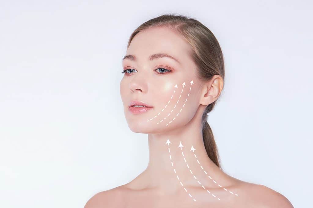 Close-up portrait of young beautiful and healthy woman with arrows on her face spa